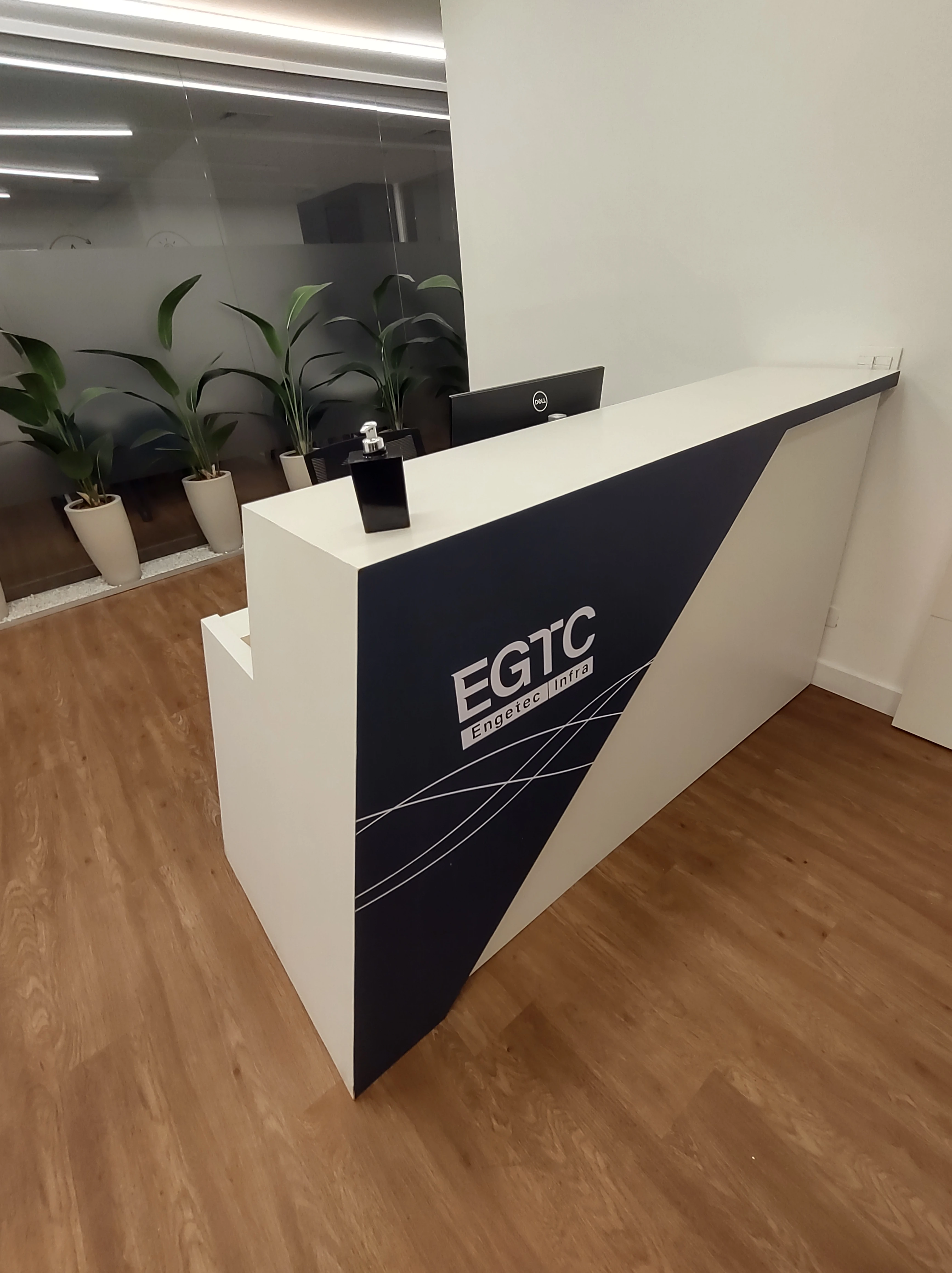 Balcão de Recepção feito com MDF branco escrito EGTC na frente